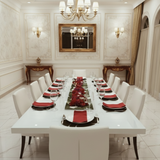 Elegant dining room with a long table set for dinner, red and white tableware, and decorative elements.
